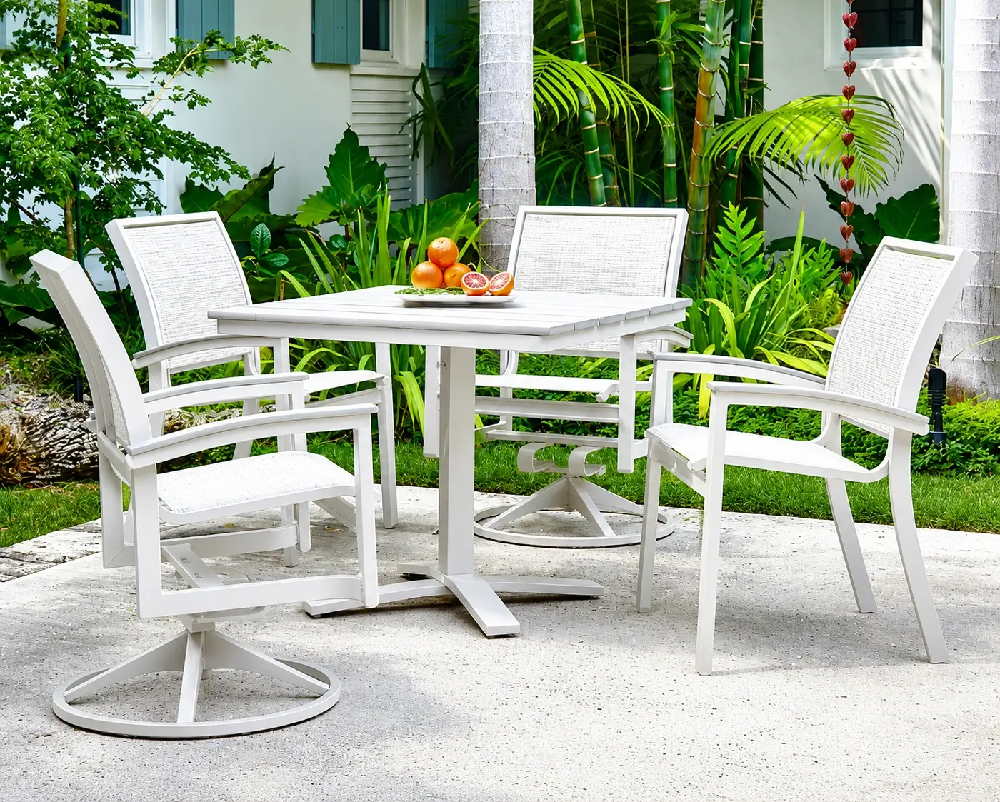 Elegant white outdoor dining set with woven sling chairs creating a refined resort-inspired patio and poolside dining space.